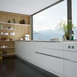 Дизайн белой кухни на фоне панорамного окна