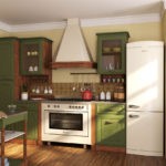 Холодильник белого цвета в интерьере кухни с зеленым гарнитуром