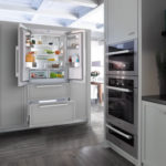 Холодильник в интерьере кухни в светло-сером шкафу