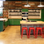 Красные барные стулья и зеленые кухонные шкафы