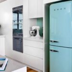 Бирюзовый холодильник на кухне с белой мебелью