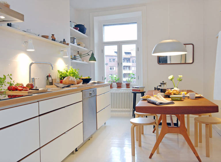 Деревянный стол в белой кухне скандинавского стиля