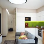 Серый диван посередине кухни в панельном доме