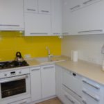 Желтый фартук в белой кухне