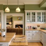 Зеленые стены кухни с белой мебелью