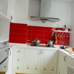 Красный фартук в белой кухне