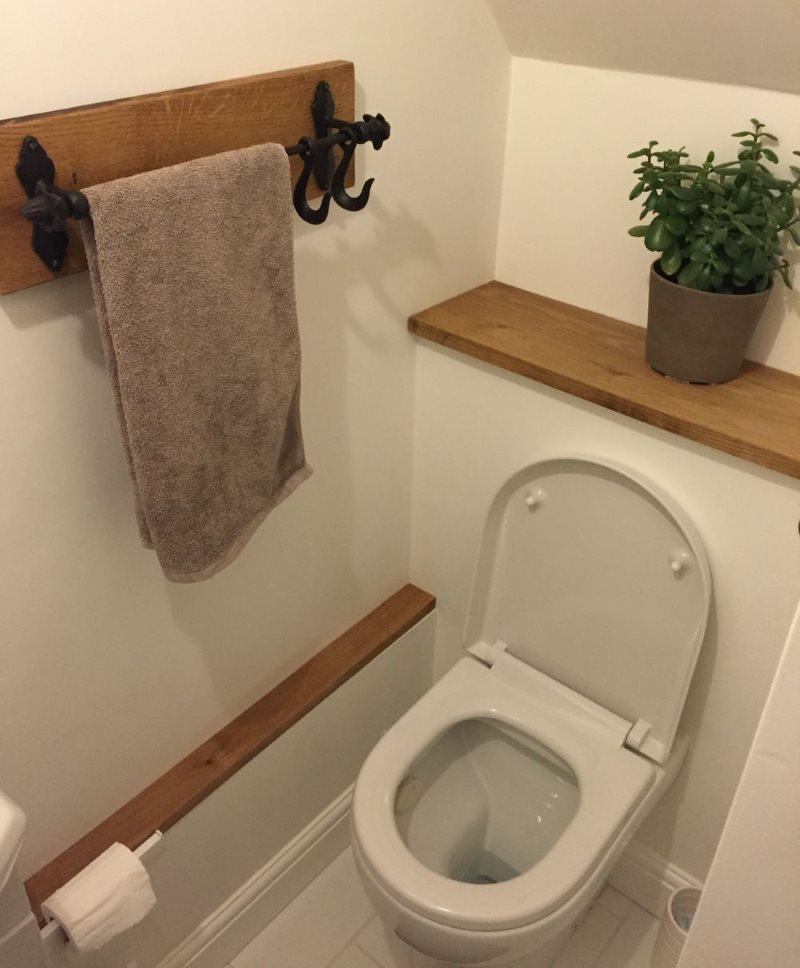Комнатный цветок на деревянной полочке в туалете