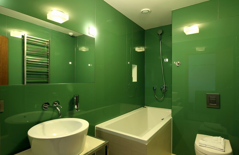 Белая сантехника в ванной с зелеными стенами