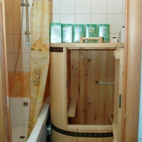 Мини-сауна в виде деревянной бочки около ванны