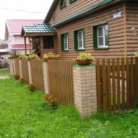 Деревянный забор на кирпичных столбах