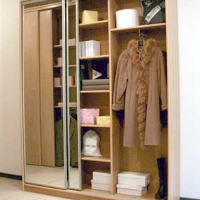 Женское пальто внутри трехстворчатого шкафа купе