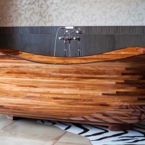 Деревянная ванна у стены с серой плиткой