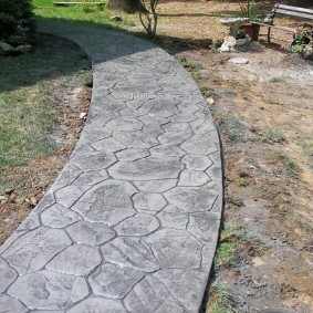 Имитация камня на серой поверхности бетонной дорожки