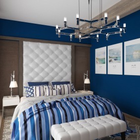 Белое изголовье кровати в спальне с обоями синего цвета
