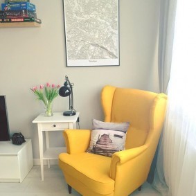 Желтое кресло на деревянных ножках