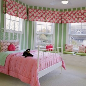 Розовое одеяло на кровати девочки
