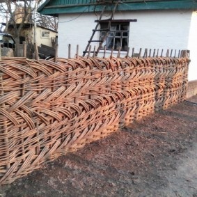 Плетенный забор перед деревенским домом
