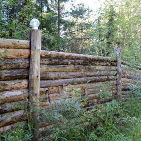 Прочный забор из толстых бревен