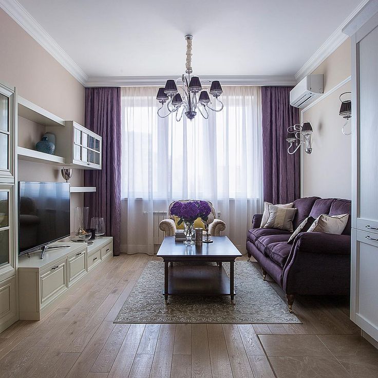 Небольшая гостиная с фиолетовым диваном у стены