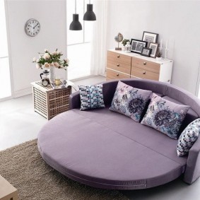 Круглый диван с фиолетовой обивкой