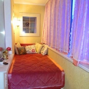 Кровать на балконе с розовыми занавесками
