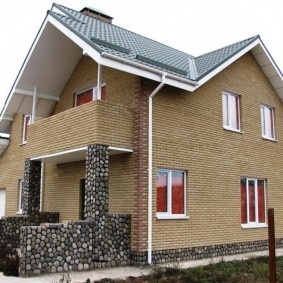 Кирпичный дом с балконом над крыльцом