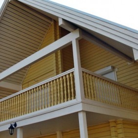 Деревянное ограждения балкона в мансарде сельского дома