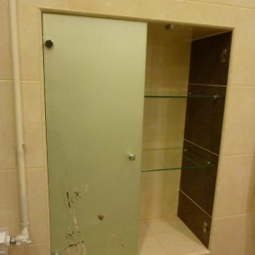 Стеклянная дверка в нише стены ванной комнаты