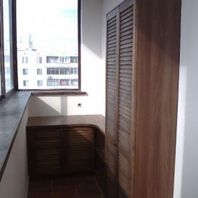 Деревянный шкафчик для одежды на застекленном балконе
