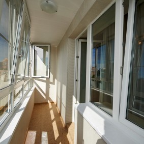 Остекление длинного балкона в трехкомнатной квартире
