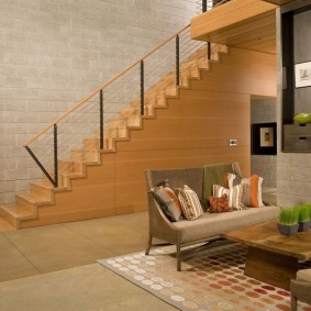 Дизайн гостиной комнаты с лестницей вдоль стены