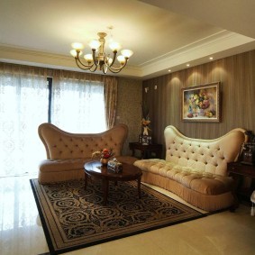 Два роскошных дивана в комнате с коричневыми обоями