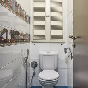 Синяя плитка на полу в маленьком туалете