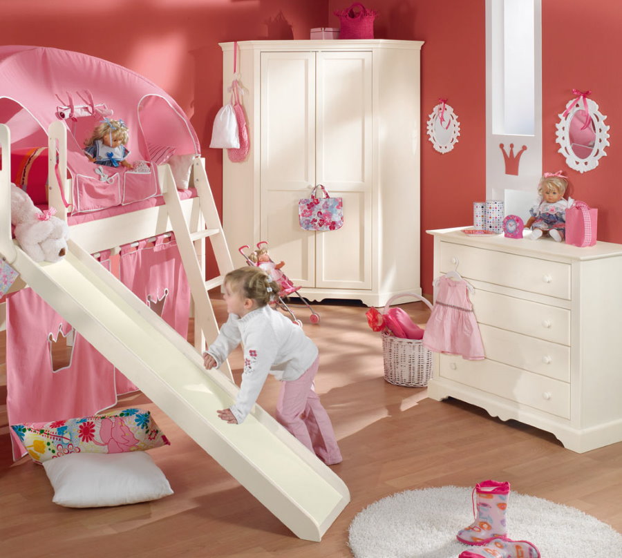 Детская кровать в комнате с розовыми стенами