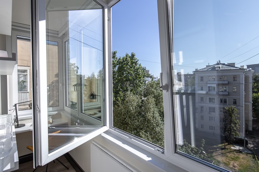 Открытая створка пластикового окна на балконе