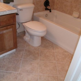 Квадратная плитка на полу ванной комнаты