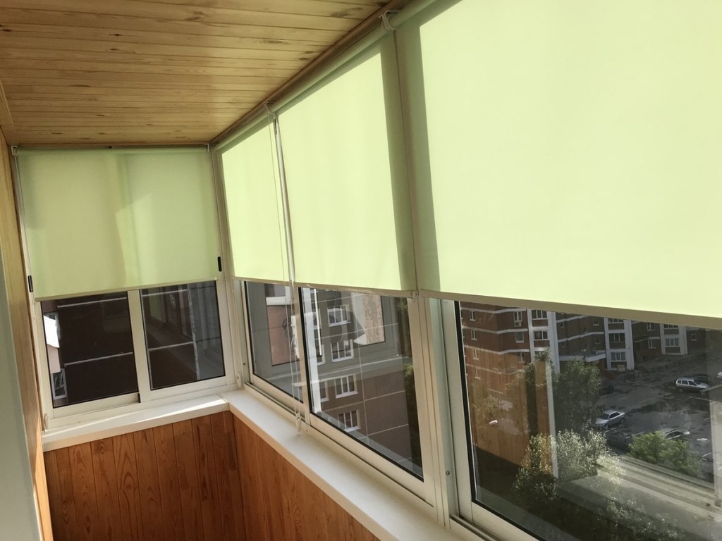 Светлые рулонные шторы на ПВХ-окнах балкона